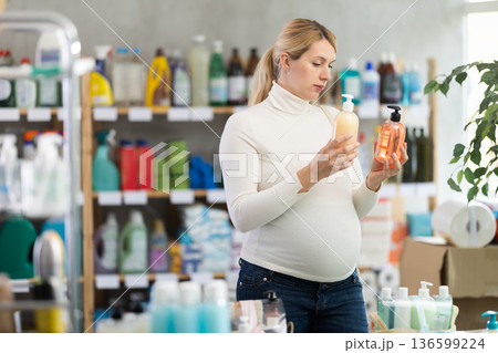 Future mom choosing natural liquid soap in home care store 136599224