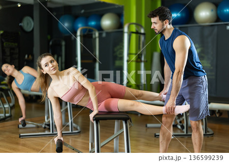 woman doing deep abdominal activation exercise on with trainer 136599239
