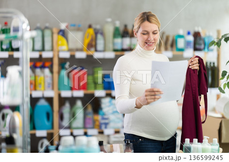 Cheerful pregnant store employee ready to leave work for motherhood Cheerful pregnant store employee ready to leave work for motherhood 136599245