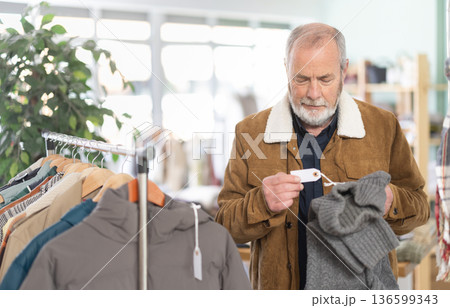 Elderly man choosing jersey knitted sweaters 136599343