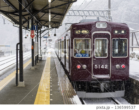 雪が降る駅に停まる能勢電鉄の5100系電車 136599537