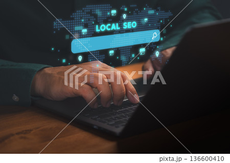 Person using laptop with glowing Local SEO search bar, representing digital marketing, online visibility, business optimization, and local search engine strategies for brand growth and promotion. Person using laptop with glowing Local SEO search bar, representing digital marketing, online visibility, business optimization, and local search engine strategies for brand growth and promotion. 136600410