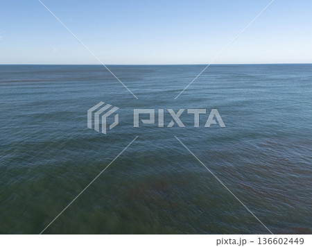 Wide view of the ocean under clear blue sky during daytime 136602449