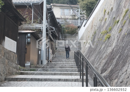 石段を登る男性の後ろ姿と日本の古い町並み風景 石段を登る男性の後ろ姿と日本の古い町並み風景 136602932