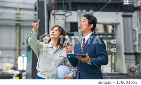 工場を視察するビジネスマンと作業員 136603058