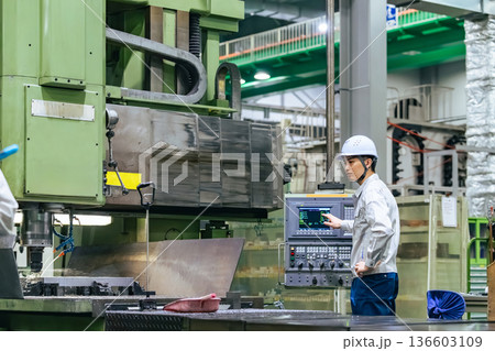 工場で操作盤で機械を操作する男性作業員 136603109