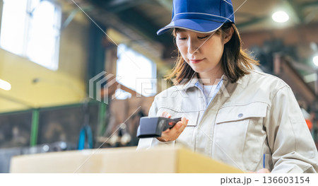 工場でハンディターミナルを使って商品を管理する女性作業員グループ 136603154