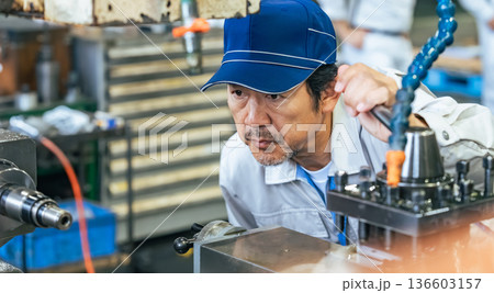 工場で機械を操作する男性作業員 工場で機械を操作する男性作業員 136603157
