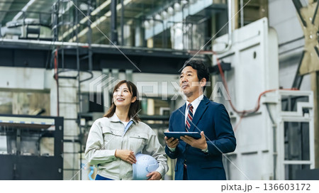 工場を視察するビジネスマンと作業員 工場を視察するビジネスマンと作業員 136603172