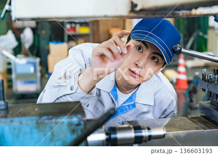 工場で機械を操作する男性作業員 工場で機械を操作する男性作業員 136603193