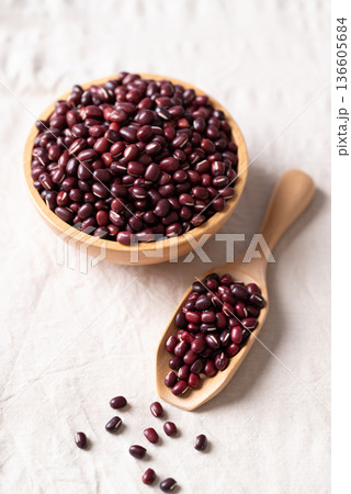 Azuki beans, Adzuki bean or red mung beans in wooden bowl and spoon on white fabric background Azuki beans, Adzuki bean or red mung beans in wooden bowl and spoon on white fabric background 136605684