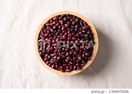 Azuki beans, Adzuki bean or red mung beans in wooden bowl on white fabric background Azuki beans, Adzuki bean or red mung beans in wooden bowl on white fabric background 136605686