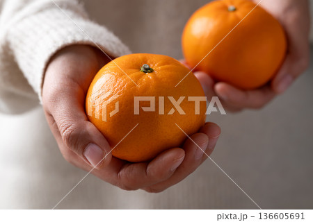Mandarin tangerine orange fruit holding by woman hand 136605691