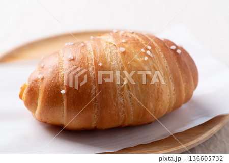 Salt bread (Shio pan) with sea salt flakes on a wooden plate, Japanese bakery style Salt bread (Shio pan) with sea salt flakes on a wooden plate, Japanese bakery style 136605732