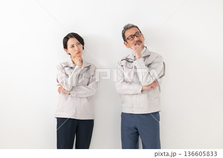考える作業服を着た男女 考える作業服を着た男女 136605833