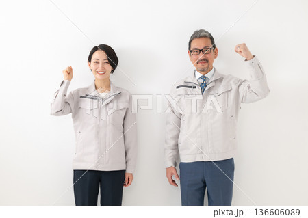 作業服を着てガッツポーズをする男女 作業服を着てガッツポーズをする男女 136606089
