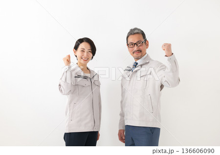 作業服を着てガッツポーズをする男女 作業服を着てガッツポーズをする男女 136606090
