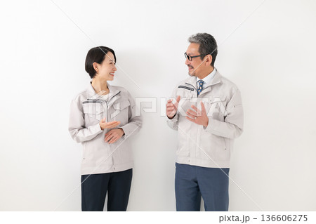 作業着を着て会話する男女 作業着を着て会話する男女 136606275