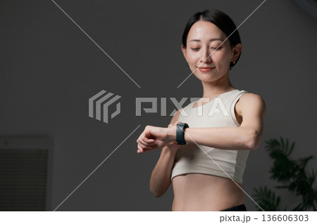 スマートウォッチを見る筋トレする女性 136606303