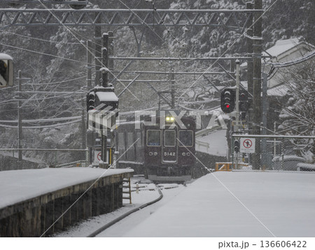 雪が積もる駅に入線する能勢電鉄の5100系電車 雪が積もる駅に入線する能勢電鉄の5100系電車 136606422