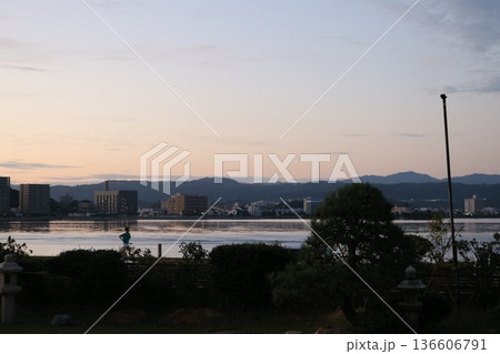夕暮れの水辺と街並みを望む静かなひととき 夕暮れの水辺と街並みを望む静かなひととき 136606791