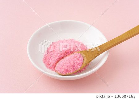 ピンク色の背景にお皿とスプーンに載せた桜でんぶ 136607165