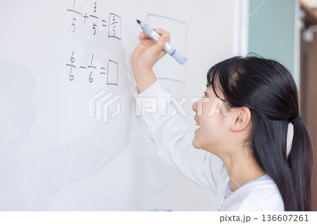 ホワイトボードに分数を書き込む小学生 ホワイトボードに分数を書き込む小学生 136607261
