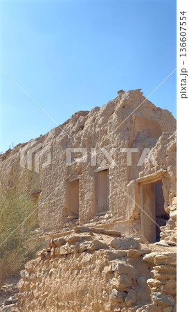 Ancient Sandstone Homes. Archaeologist Observes Historic Sandstone Structures. Sunlit Erosion Reveals Crumbling Sandstone Homes And Ancient Passageways On Steep Escarpment Ancient Sandstone Homes. Archaeologist Observes Historic Sandstone Structures. Sunlit Erosion Reveals Crumbling Sandstone Homes And Ancient Passageways On Steep Escarpment 136607554