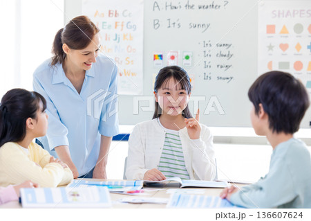 教育　英会話教室でレッスンを受ける子供とネイティブ講師のポートレート 136607624