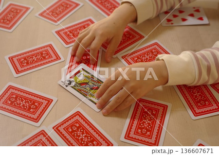 トランプの絵札をめくる子供の両手 136607671