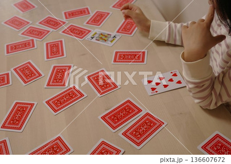 トランプの次の札を考えて悩む子供の様子 136607672