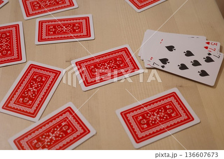 木のテーブルに並べられたトランプのカード 136607673
