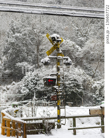 雪が積もる作動中の踏切 136607722