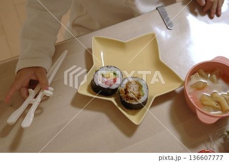 トレーニング箸で巻き寿司を食べる子供 136607777