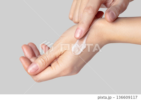 Close up photo woman hands with a white swatch sampled with a smear of cream. Self-care concept, skin care, hand care, facial care. Isolated gray background photo Close up photo woman hands with a white swatch sampled with a smear of cream. Self-care concept, skin care, hand care, facial care. Isolated gray background photo 136609117