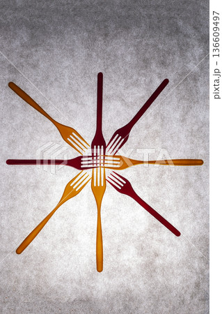 Yellow and red plastic forks on a gray background Yellow and red plastic forks on a gray background 136609497