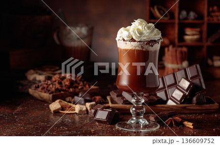 Hot chocolate with whipped cream in a glass mug. 136609752