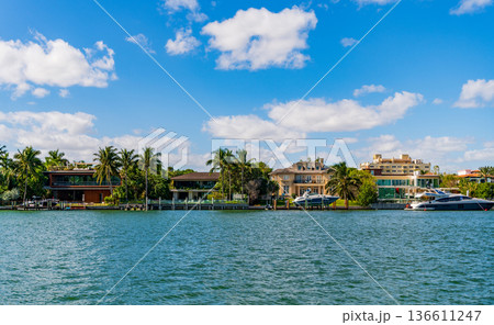 Residential waterfront apartment with boat. Waterfront landscape with house. Vacation in summer. Luxury waterfront hotel building. Summer vacation. Yacht in luxury residential area 136611247