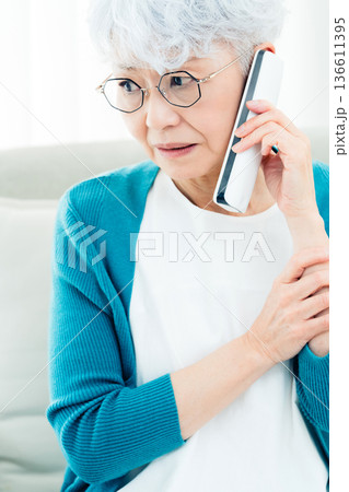 固定電話で通話するシニア女性 固定電話で通話するシニア女性 136611395