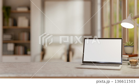 White screen laptop and coffee under lamp on marble table aside window in a living room or library. 136611503