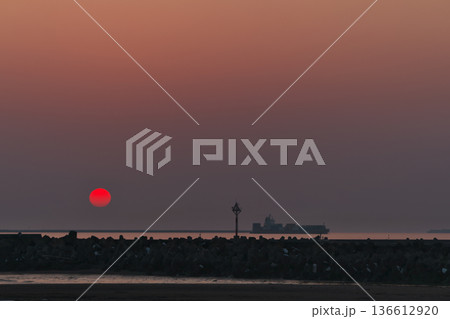 太平洋・北海道浜厚真の真っ赤な真ん丸夕日と貨物船 136612920