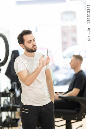 Barber preparing scissors for client grooming service Barber preparing scissors for client grooming service 136613341