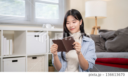 Asian woman holding passport while organizing or packing a luggage on bedroom or living room's floor Asian woman holding passport while organizing or packing a luggage on bedroom or living room's floor 136613670
