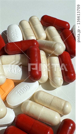 Detailed View Of Pharmaceutical Capsules On Clean White Background. Highresolution Image Showcasing Red And Beige Capsules With Sharp Shadows And Textured Surface 136613709