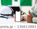 スマホを持って喜ぶ作業員の手元 136613883