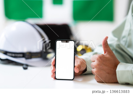 スマホを持って喜ぶ作業員の手元 スマホを持って喜ぶ作業員の手元 136613883