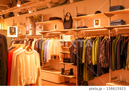 Clothing store interior with fashion apparel on racks and shelves, shopping for new collection in Paris France Clothing store interior with fashion apparel on racks and shelves, shopping for new collection in Paris France 136615923