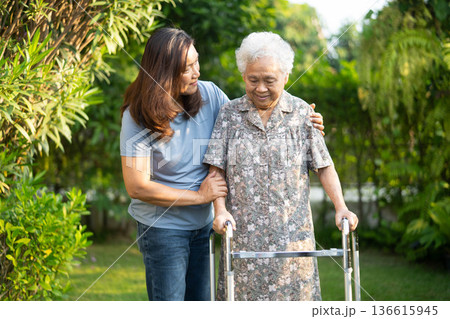 Asian elderly woman disability patient walk with walker in park. Asian elderly woman disability patient walk with walker in park. 136615945