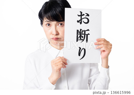 お断りと書かれた紙を持つカメラ目線の白いシャツを着たシニア女性 お断りと書かれた紙を持つカメラ目線の白いシャツを着たシニア女性 136615996