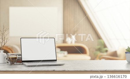 White screen laptop with coffee and book on marble counter table in attic living room with sunlight. 136616170